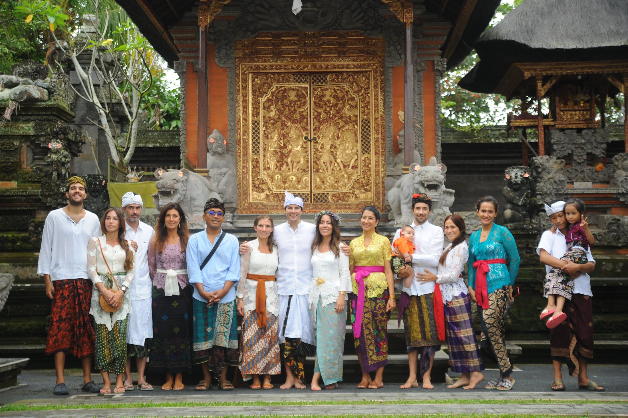 Boda balinesa en un templo de Ubud: los novios con sus invitados vestidos con trajes tradicionales ante la puerta dorada