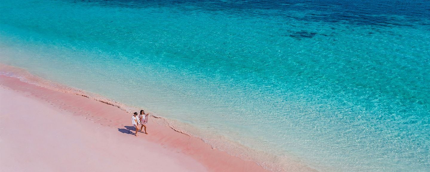 Pareja paseando por la playa rosa de Komodo